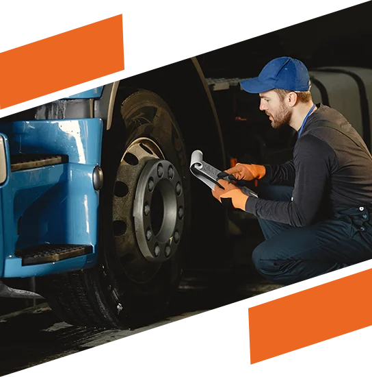 A young worker checks wheel. Truck malfunction. Service work.